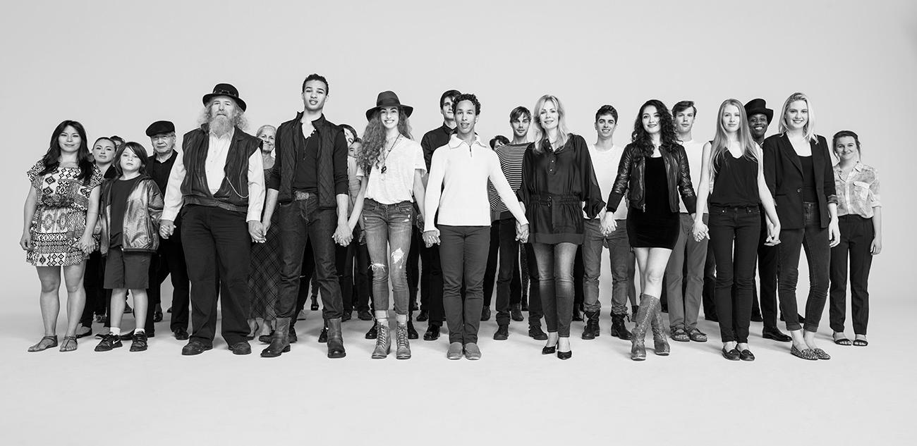 group of people holding hands and standing while looking directly at the camera