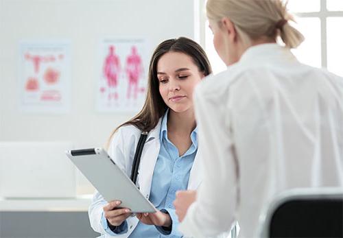 two female doctors looking at clipboard