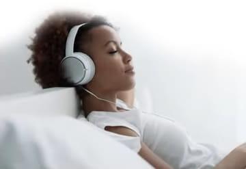 Women napping in bed with headphones on