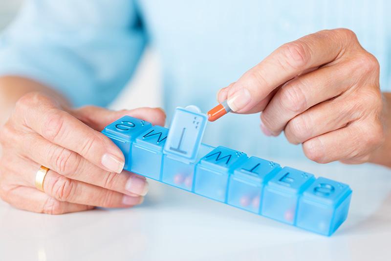 woman hands placing pills in sorter