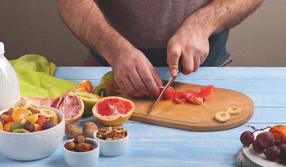 Person cutting fruit on a cutting board