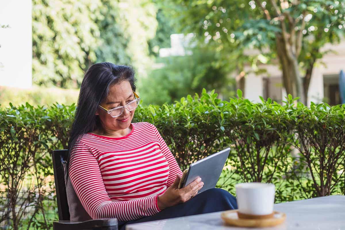 Portrait of Asian woman using digital tablet computer at home outdoors